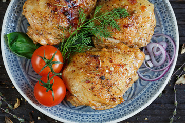Roasted chicken and vegetables on dark wooden background