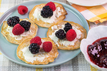 Cornmeal cakes garnish with fresh berries and bowl of berry fig