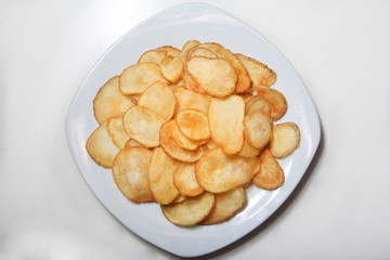 Potato chips isolated on white plate