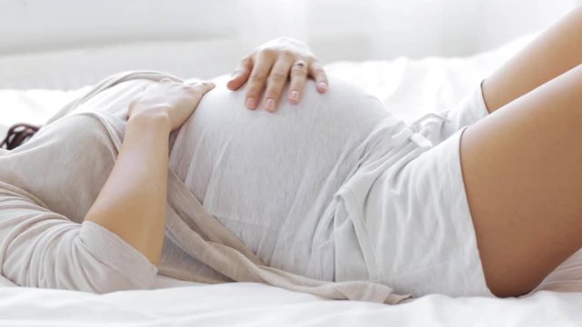 happy pregnant woman touching her tummy at home 42
