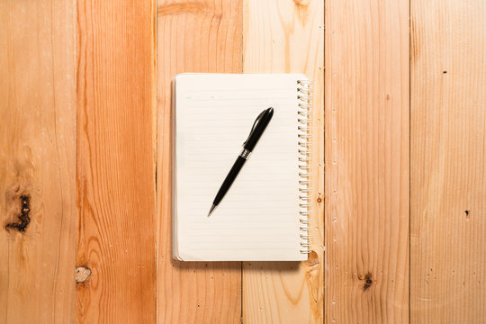 Pen and Notepad on the wooden desk./ Pen and Notepad on the wooden desk