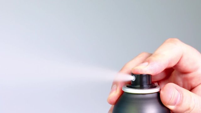 Finger pressing down three times on black aerosol can