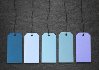 Blaue Kartonanhänger auf Schiefertafel
