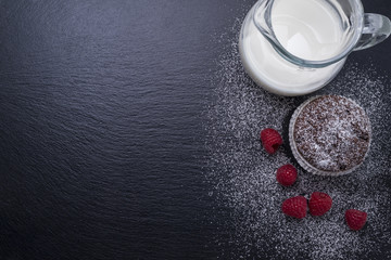 Schokomuffin mit Himbeeren und Milch auf Schiefertafel - Hintergrund