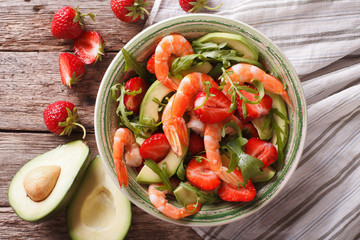 Tasty food: salad with shrimp, avocado and strawberry closeup. horizontal top view

