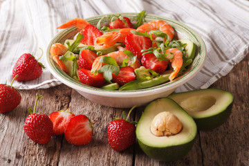 Gourmet Seafood salad with strawberries and avocado close-up on the table
