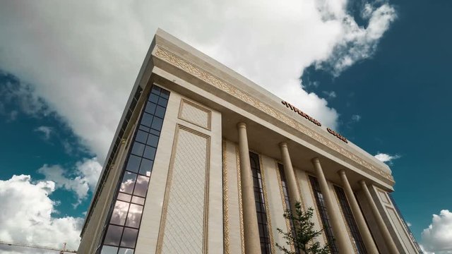 Clouds over the building of the concert hall of the administrative and business center. Kazakhstan - 4K Timelapse