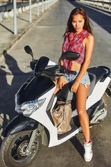Foto op Plexiglas Young beautiful brunette girl posing on a scooter © paultarasenko