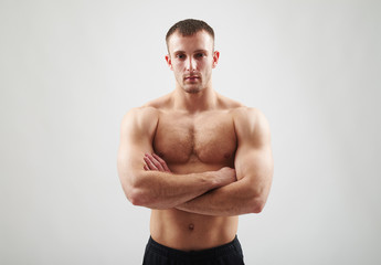Fototapeta premium Bare-chested man is standing with crossed arms.