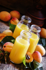 Freshly squeezed apricot juice in glass bottles, fresh fruit wit