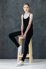 Young European woman posing in studio for test photo shoot showing different poses sitting on bar stool