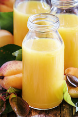 Freshly squeezed apricot juice in glass bottles, fresh fruit wit