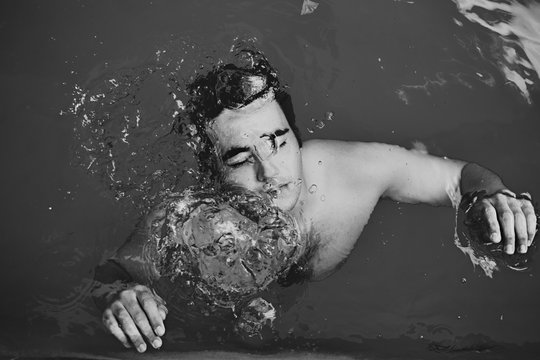 Man underwater with eyes closed