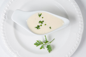 Obraz na płótnie Canvas Tasty Bechamel sauce or white sauce with fresh greenery
