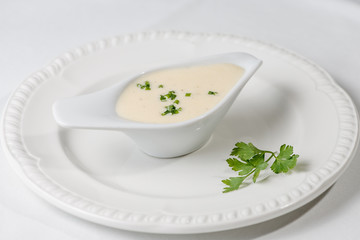 Tasty Bechamel sauce or white sauce with fresh greenery