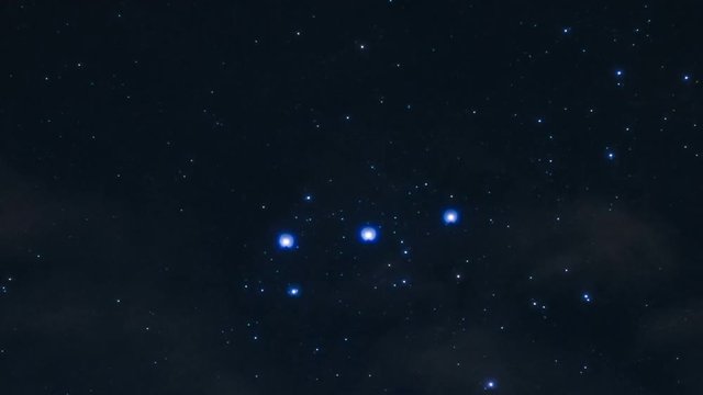 zooming time lapse of the stars of constellation Orion moving in the background of night clouds
