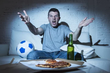 Rolgordijnen angry football fan ball and beer bottle watching tv soccer screaming upset © Wordley Calvo Stock