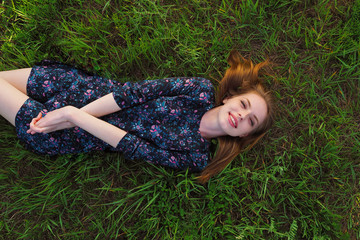 Top portrait of young woman laying on the grass in the park