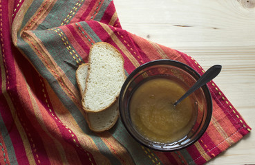 Healthy breakfast: bread and honey on wooden table. Bread with honey on a red material.
