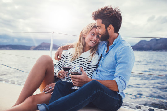 Romantic couple holding wine glasses on yacht