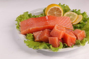 salmon on a plate with salad and lemon