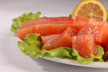 salmon on a plate with salad and lemon