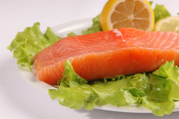 salmon on a plate with salad and lemon