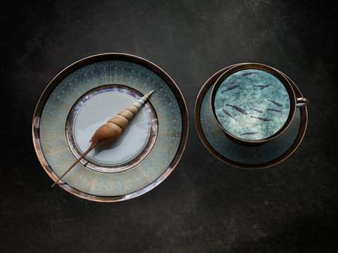 Shell on plate, fish swimming in teacup