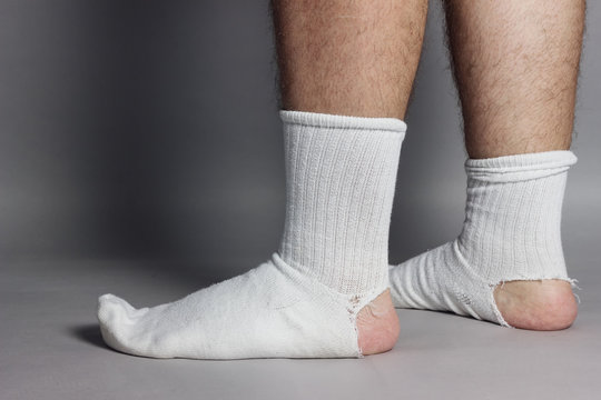 sideways standing feet with white socks and a big hole in front