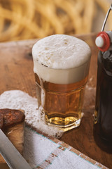  glass with beer and some sausage on the side