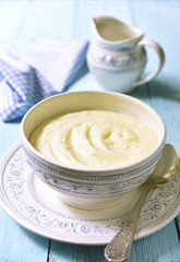 Semolina porridge in a vintage bowle on blue wooden table.