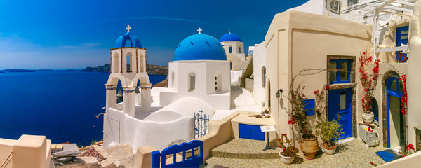 Malerischer Blick auf weiße Häuser und Kirche mit blauen Kuppeln in Oia oder Ia, Insel Santorini, Griechenland