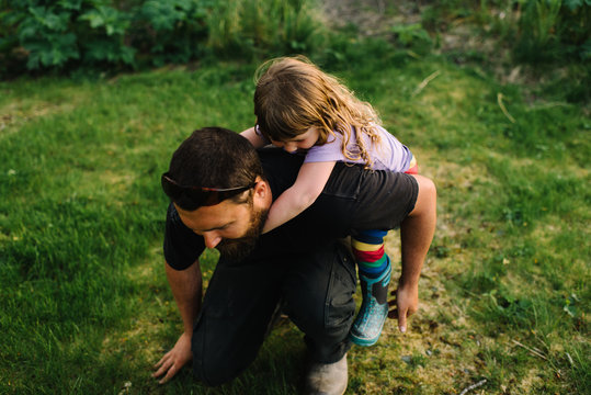 Father giving daughter piggyback, outdoors