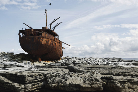 Rusted shipwreck on rocks 