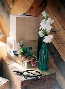 Gift boxes and glass bottle with flowers, still life