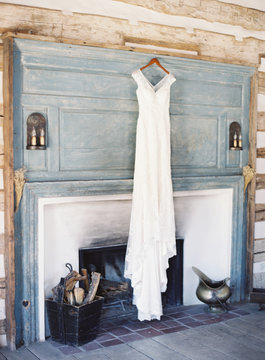 Wedding dress hanging up on fireplace