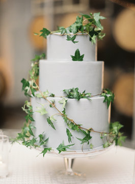 Ivy covered wedding cake on glass stand