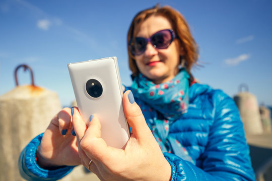 woman taking self-portrait on smartphone