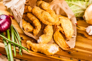 Chicken nuggets and fries on wooden board