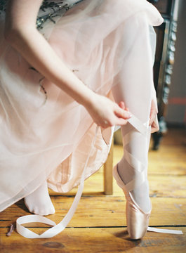 Woman putting on ballet shoes
