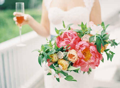 Bride holding bouquet and champagne flute 
