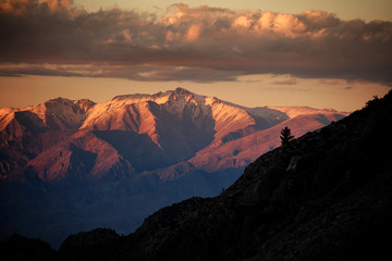 Sunlight on snow capped mountains under cloudscape