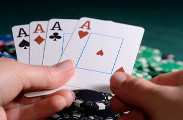 Casino chips and four of kind combination in a woman's hand. Poker game concept