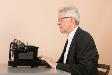 Senior man with antique typewriter