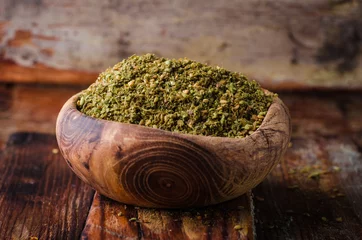 Gardinen Mixed east spice - zaatar or zatar in vintage bowl on wooden background. Selective focus © tanchy25