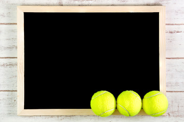 Blank blackboard and Tennis ball on wooden table.Template mock u
