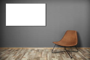 Wicker chair and picture frame on dark grey wall background