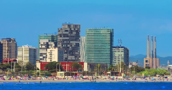 Barcelona beach. Timelapse of Barcelona city beach view. Resort at Spain. Travel destination. Time lapse of mediterranean coast in Barcelona at sunny day. Cloudless sky over buildings at sea beach