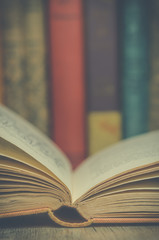 Vintage open book with books in background 