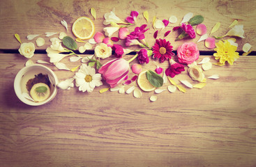 Fototapeta na wymiar Cup of tea with beautiful flowers on wooden background